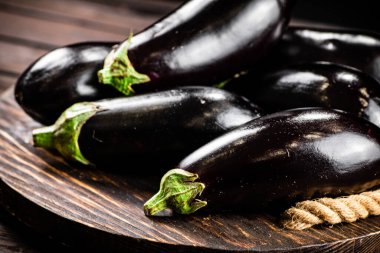 Ripe eggplant on a wooden tray. On a wooden background. High quality photo
