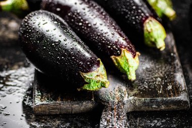 Ripe eggplant with droplets of water. On a black background. High quality photo