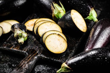 Cut into pieces on a cutting board of eggplant. On a black background. High quality photo