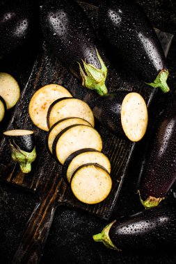 Cut into pieces on a cutting board of eggplant. On a black background. High quality photo