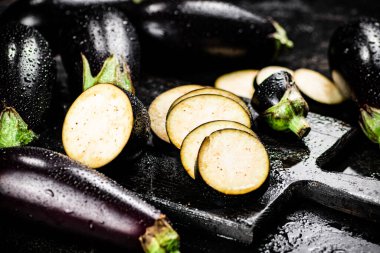Cut into pieces on a cutting board of eggplant. On a black background. High quality photo