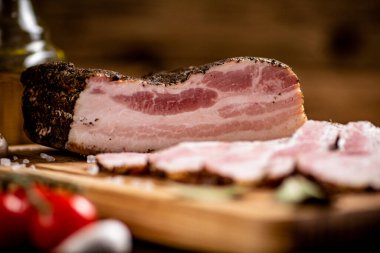 A delicious homemade piece of lard on a cutting board. On a wooden background. High quality photo