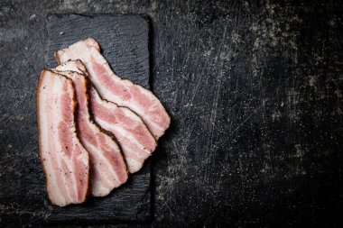 Sliced homemade lard on a stone board. On a black background. High quality photo