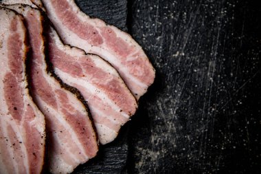 Sliced homemade lard on a stone board. On a black background. High quality photo