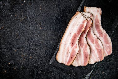 Sliced homemade lard on a stone board. On a black background. High quality photo