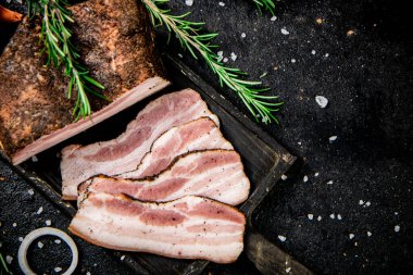 Sliced pork lard with rosemary. On a black background. High quality photo