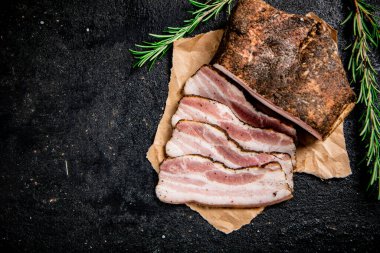 Sliced pork lard with rosemary. On a black background. High quality photo
