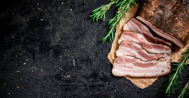 Sliced pork lard with rosemary. On a black background. High quality photo