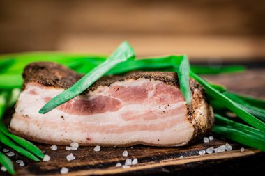 Delicious pork lard with green onions. On a wooden background. High quality photo