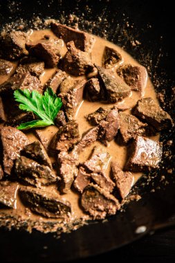 Fragrant fried liver in a saucepan. Macro background. High quality photo