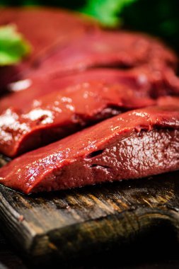 Sliced raw liver with greens. Macro background. High quality photo