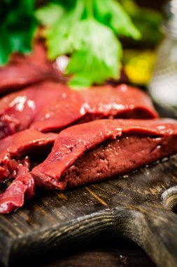 Sliced raw liver with greens. Macro background. High quality photo