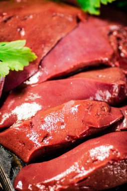 Sliced raw liver with greens. Macro background. High quality photo