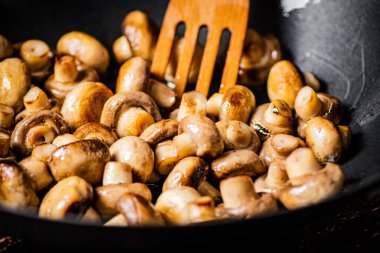 Mushrooms are fried in a frying pan. Macro background. High quality photo