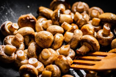Mushrooms are fried in a frying pan. Macro background. High quality photo
