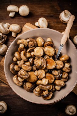 Fried mushrooms in a bowl on a cutting board. On a wooden background. High quality photo