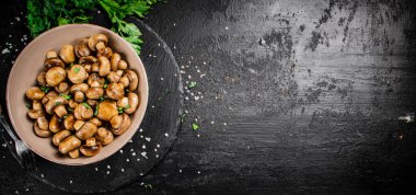 Delicious fried mushrooms in a bowl. On a black background. High quality photo