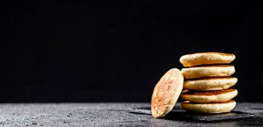 Ready made homemade pancakes on a stone board. On a black background. High quality photo