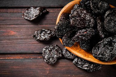 Prunes in a plate on a wooden background. Top view. High quality photo