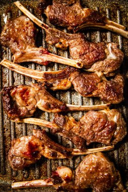 A rack of lamb in a grill pan. Macro background. Top view. High quality photo