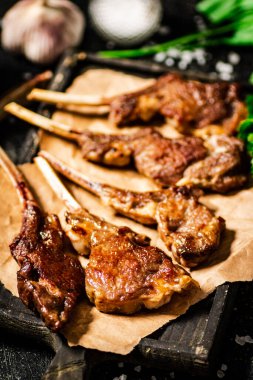Delicious homemade grilled lamb rack. On a black background. High quality photo