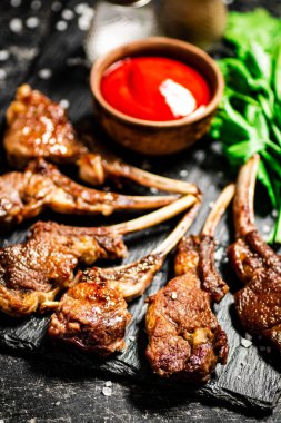 Delicious homemade grilled lamb rack. On a black background. High quality photo