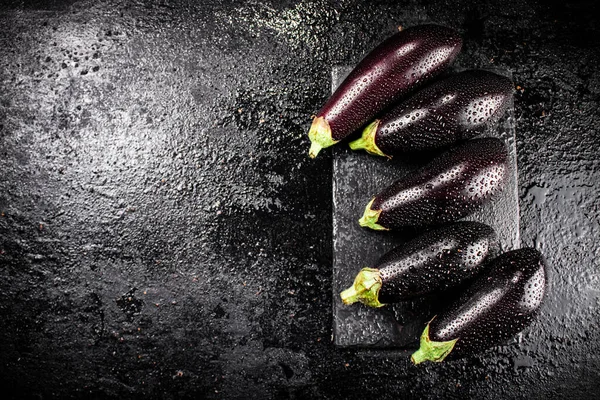 Fresh Ripe Eggplant Droplets Water Stone Board Black Background High — 图库照片