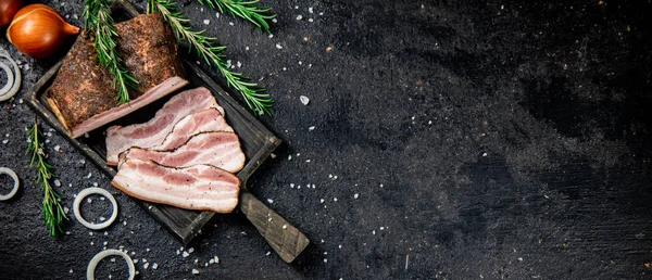 Sliced pork lard with rosemary. On a black background. High quality photo