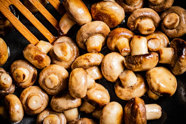 stock image Mushrooms are fried in a frying pan. Macro background. High quality photo