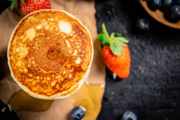 Ein Haufen Pfannkuchen Mit Beeren Und Honig Auf Schwarzem Hintergrund — Stockfoto
