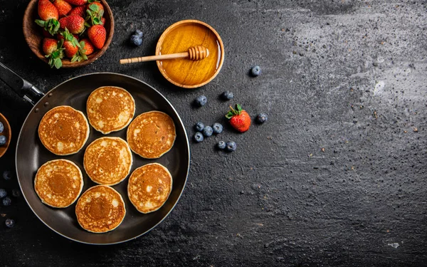 Pancakes Frying Pan Fresh Berries Honey Black Background High Quality lizenzfreie Stockbilder