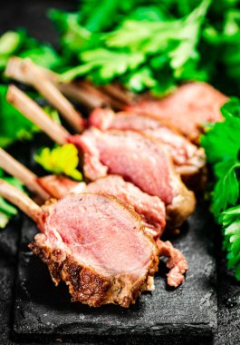 Rack of grilled lamb with parsley. On a black background. High quality photo