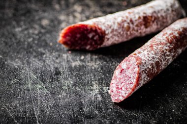 Sticks of salami sausage on the table. On a black background. High quality photo