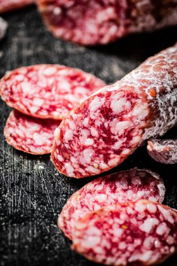 Sliced delicious salami sausage. On a black background. High quality photo