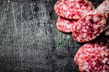 Sliced delicious salami sausage. On a black background. High quality photo