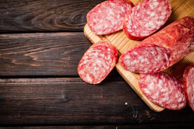 Sliced delicious salami sausage on the table. On a wooden background. High quality photo