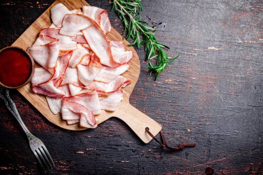 Domates soslu pastırma dilimleri. Karanlık bir arka plana karşı. Yüksek kalite fotoğraf