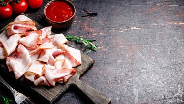 Domates soslu pastırma dilimleri. Karanlık bir arka plana karşı. Yüksek kalite fotoğraf