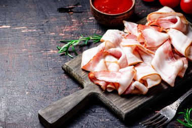 Domates soslu pastırma dilimleri. Karanlık bir arka plana karşı. Yüksek kalite fotoğraf