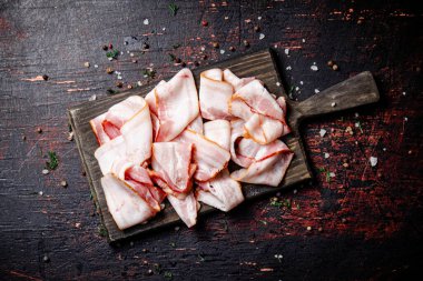 Kesme tahtasındaki baharatlı taze pastırma parçaları. Karanlık bir arka plana karşı. Yüksek kalite fotoğraf