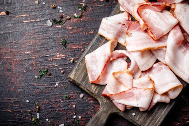 Kesme tahtasındaki baharatlı taze pastırma parçaları. Karanlık bir arka plana karşı. Yüksek kalite fotoğraf