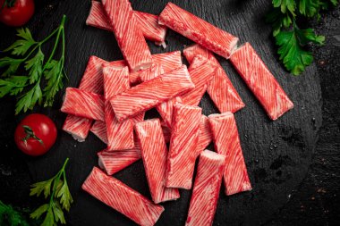 Taş tahtada taze domates ve bitkilerle yengeç eti. Siyah bir arka planda. Yüksek kalite fotoğraf