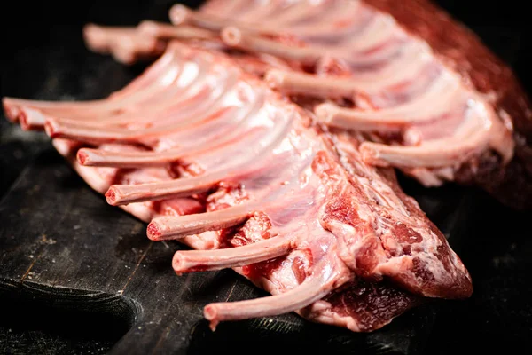 生吃的羊排放在桌上的切菜板上 在一个黑色的背景 高质量的照片 — 图库照片