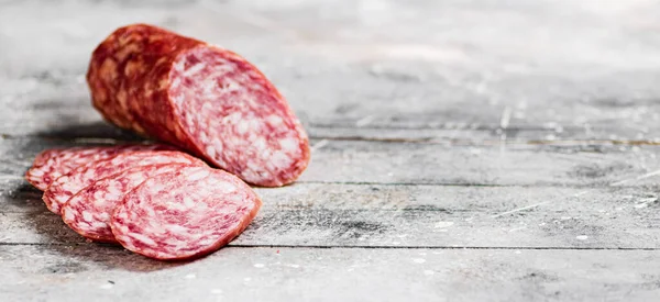 Delicious salami sausage on the table. On a gray background. High quality photo