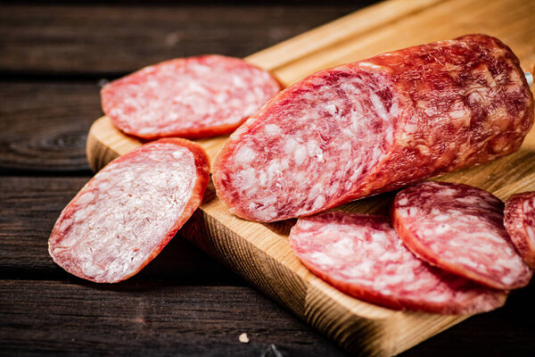 Sliced delicious salami sausage on the table. On a wooden background. High quality photo