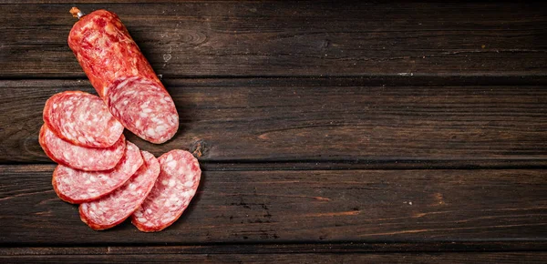 Sliced delicious salami sausage on the table. On a wooden background. High quality photo