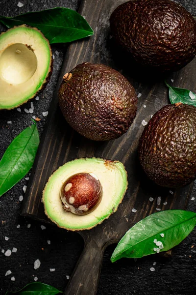 Cut Avocado Leaves Cutting Board Black Background High Quality Photo — Stockfoto
