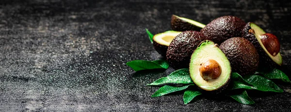 stock image Fresh avocado with leaves. On a black background. High quality photo