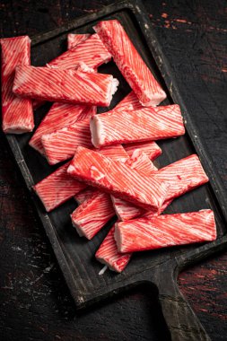 Tahta kesme tahtasındaki yengeç eti. Karanlık bir arka plana karşı. Yüksek kalite fotoğraf