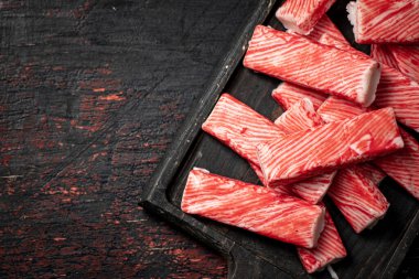 Tahta kesme tahtasındaki yengeç eti. Karanlık bir arka plana karşı. Yüksek kalite fotoğraf